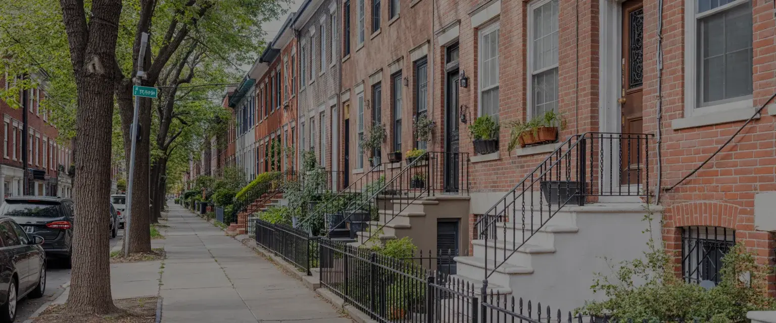 A tree-lined Philadelphia rowhome block with marble front steps